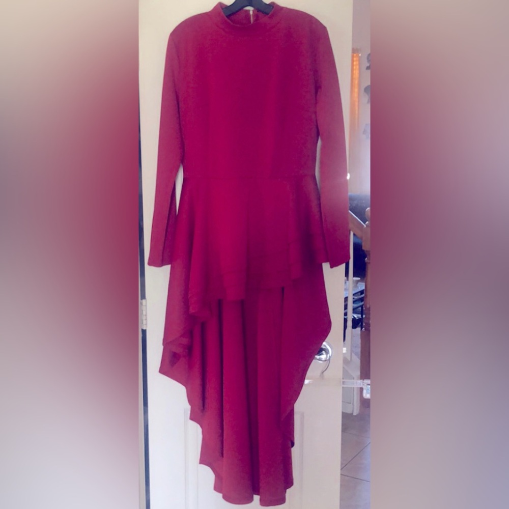 Asymmetrical hi/low long sleeve mock turtle neck top. Layered peplum.